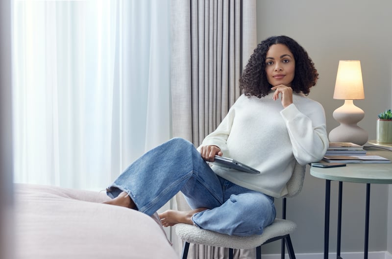 Woman reclining in chair in bedroom